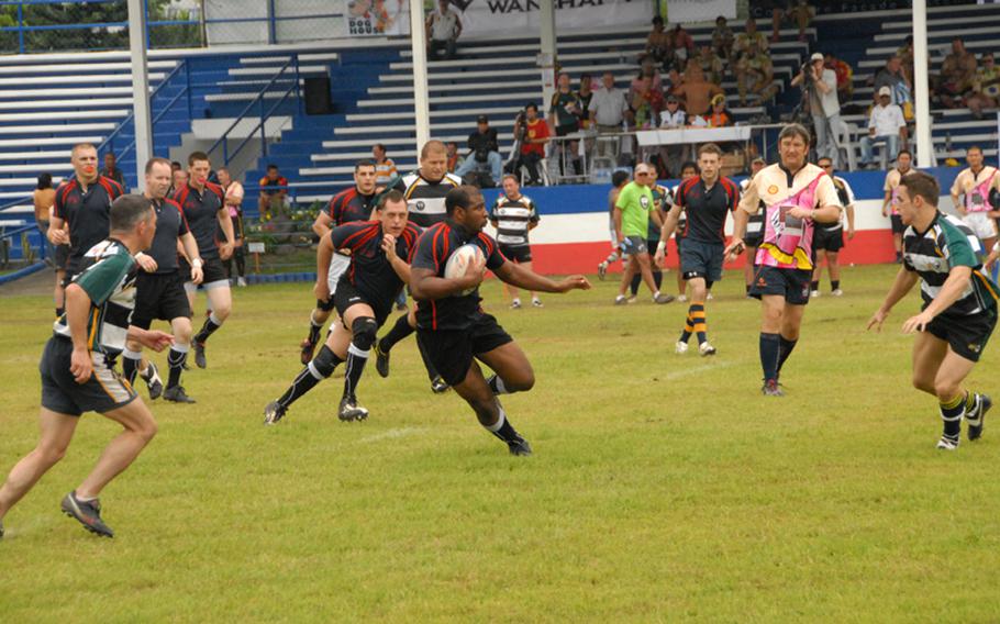 Petty Officer 2nd Class Rayshawn Coleman runs with the ball during a rugby match last September while in port in the Philippines.