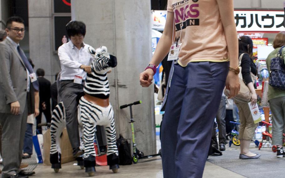A worker with Rangs Japan rides a Ripstik, a skateboard-like toy with rollerblade wheels at the toy show on June 16.