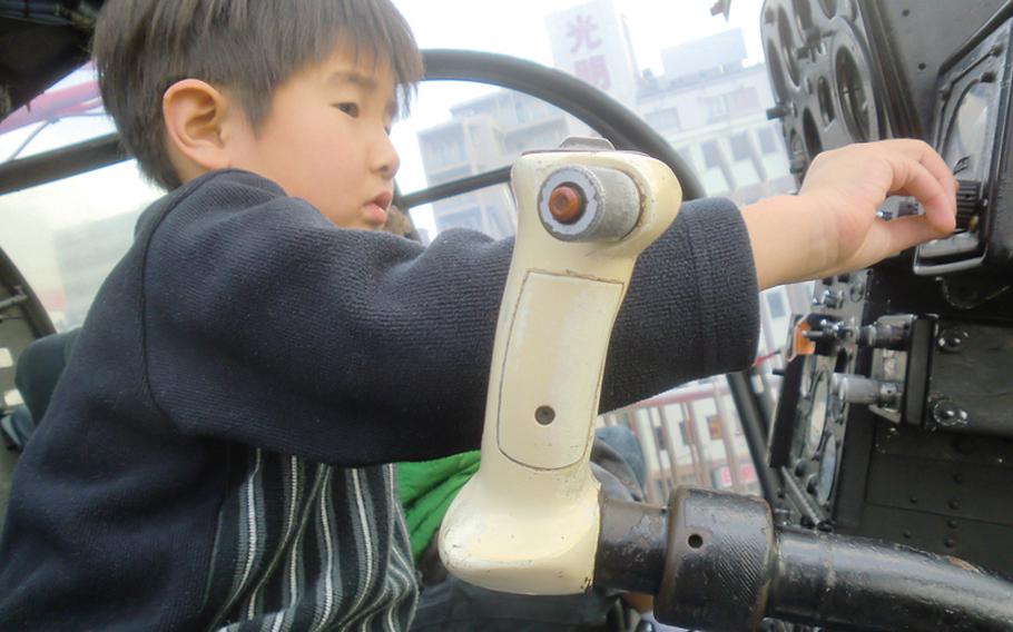 A young boy familiarizes himself with the controls of an Aerospatiale Alouette III helicopter.