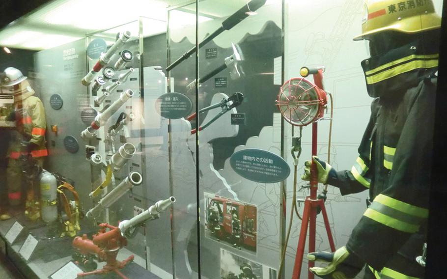 A display of firefighter uniforms and fire hose nozzles at the Tokyo Fire Museum.