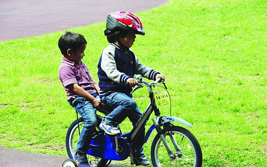 Two boys take a ride around the kiddie track on their bike rental at Yoyogi Park in Tokyo.