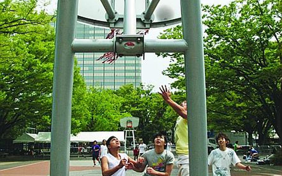 Boys play hoops on one of the two basketball courts at Yoyogi Park on a Saturday afternoon.