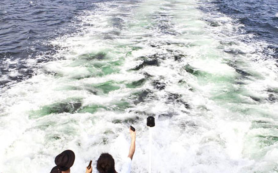 Visitors to Sarushima - or Monkey Island - take one last look as they depart this tiny island during a recent visit.