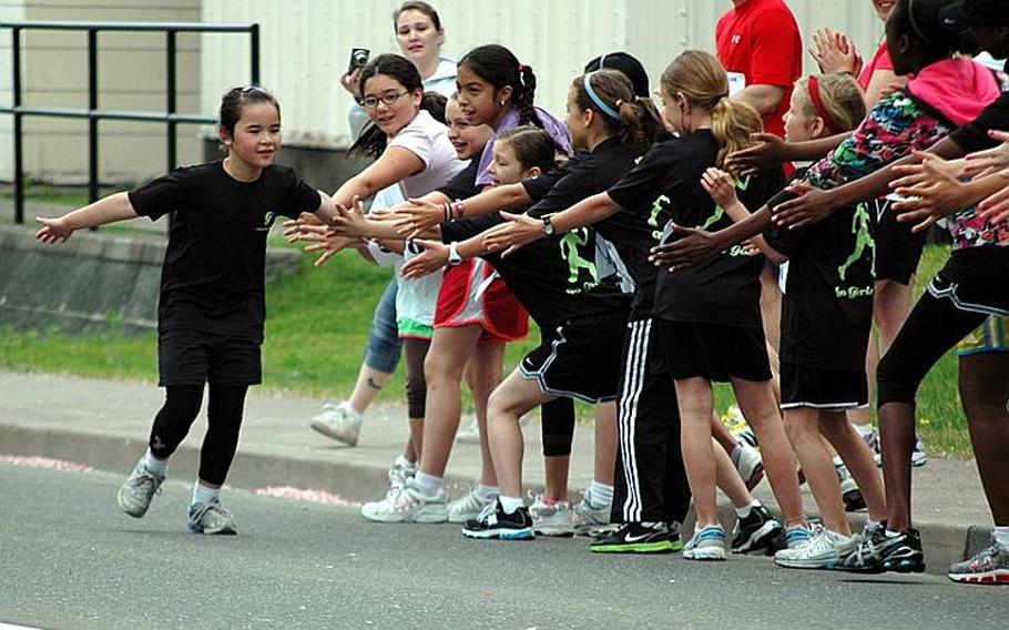 Members of the 'Go Girls Go' club cheer on a fellow teammate as she gets ready to cross the finish line during a May 21 3k race on Misawa Air Base, Japan.
