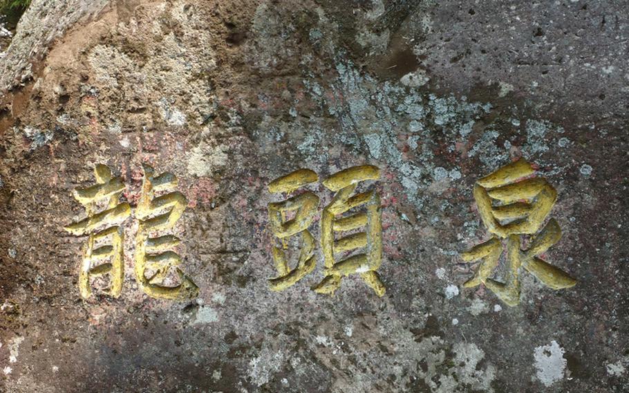 The name of the falls is written beautifully in Japanese text on a rock at the base of the falls.