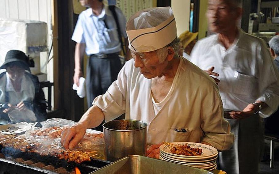 A man cooks yakitori at Yasukuni Shrine. The August 15 event gathered hundreds of people to pray and make donations.