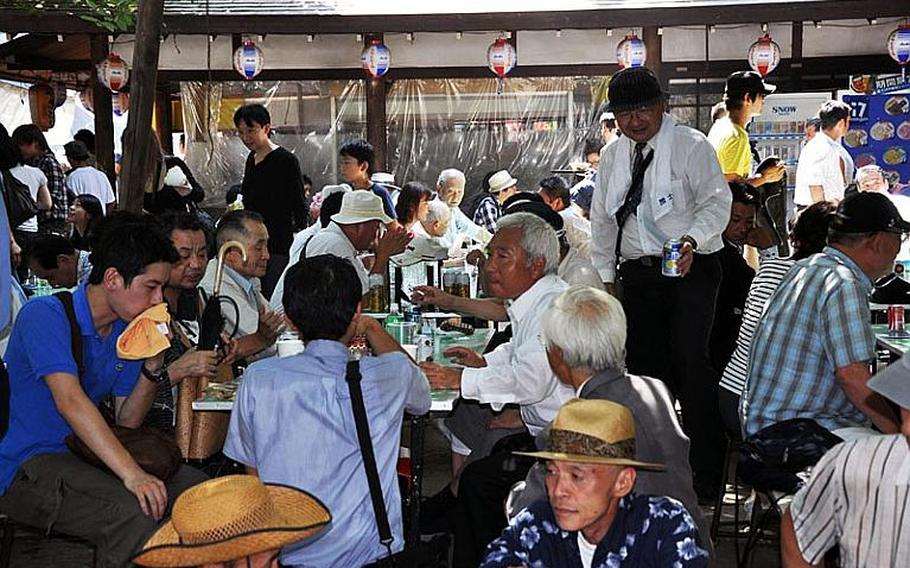 Visitors eat and drink at Yasukuni Shrine to escape the intense heat of the summer day.