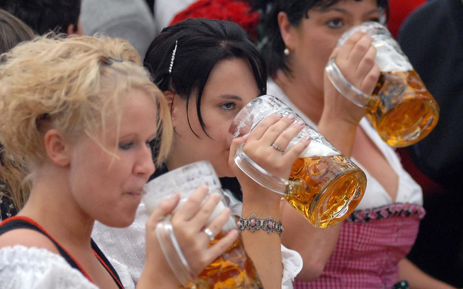 Dirndl-wearing maidens drink from liter mugs in the Ochsenbraterei tent.