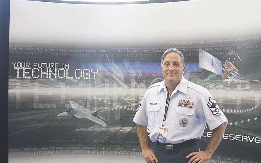 Chief Master Sgt. Scott H. Terpening poses in front of the Air Force Reserve recruiting booth at PAX Prime in Seattle on Aug. 30. Herpening said of PAX, "Obviously, we've got dancing zombies. We've got Mario, Sonic the Hedgehogs running around here. That's awesome."