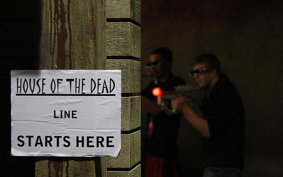 Gamers lined up to try out "House of the Dead" for the Sony PlayStation's Move controller, and afterward posed for shots with "House of the Dead" zombies.