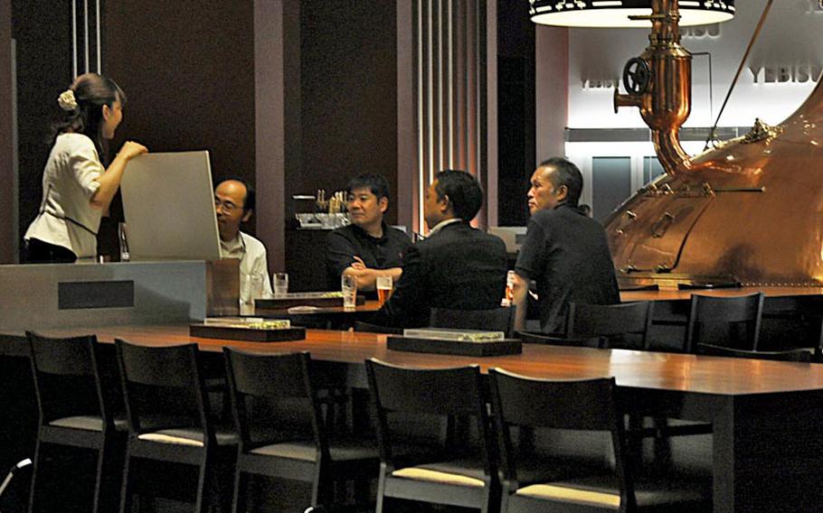 A Yebisu Beer Museum instructor teaches a class on beer to guests who took the guided tour.