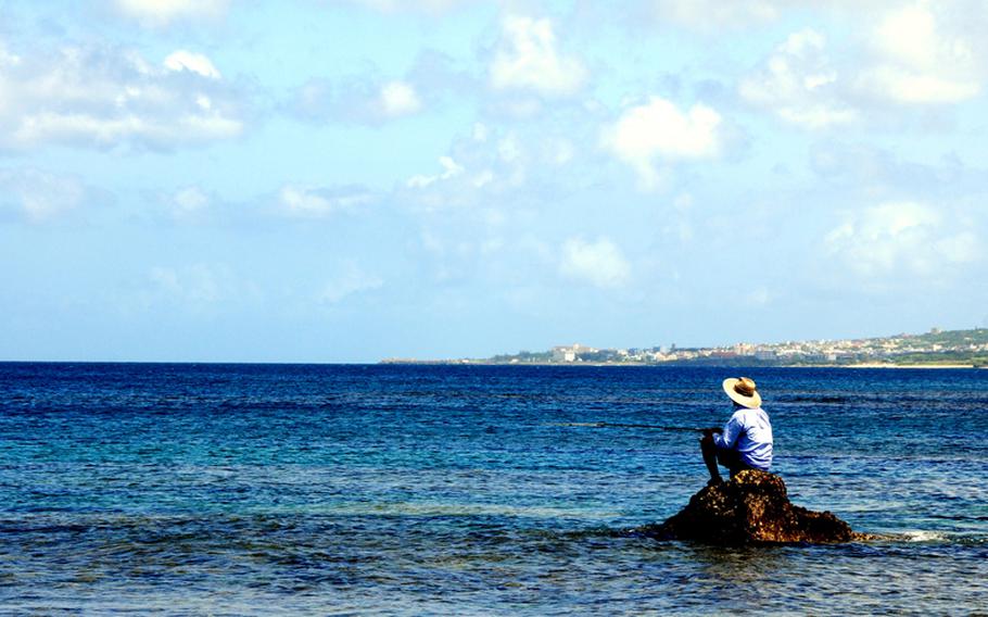 Fishing is a very popular past time for the local Okinawans. During a recent very low tide this fisherman walked to the edge of the coral reef and fished the drop off while the tide was low.