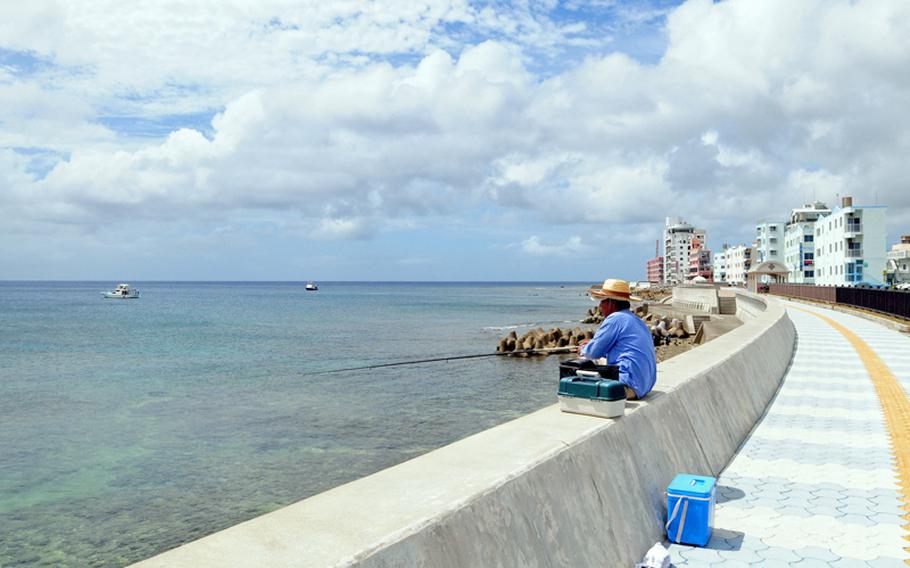 The newly constructed walkway along the Sunabe Seawall on Okinawa is used by many, including those who fish.