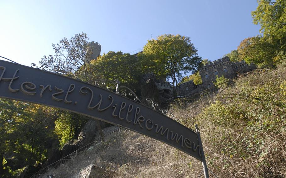 A sign in German welcomes visitors to Burg Rheinstein, a centuries-old castle built on top of a rocky cliff along the Rhine River.