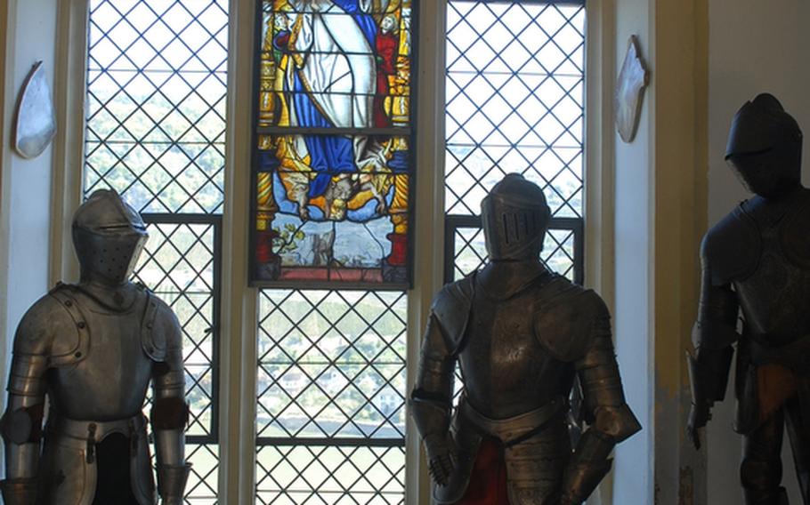 Two suits of parade armor flank a stained-glass window from the 16th century in the squires hall, one of many rooms visitors can see at Burg Rheinstein.