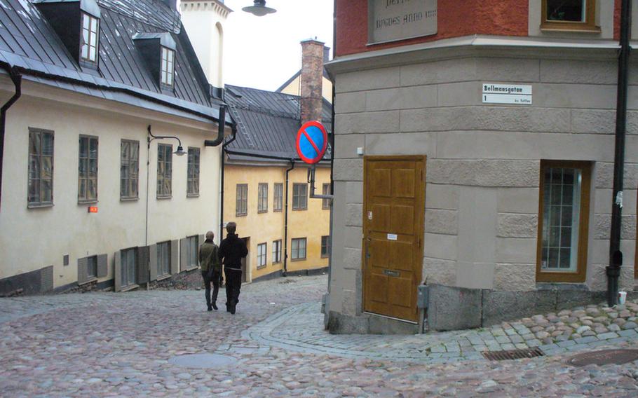 A couple strolls by Bellmansgatan 1 on Mariaberget Hill in Sodermalm, the fictional street-level entrance to journalist Mikael Blomqvist's apartment building.