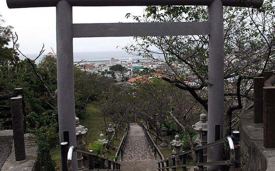 A large torii gate halfway up the staircase frames the city of Nago below. The area is surrounded by cherry blossom trees. This area would be absolutely stunning during cherry blossom season due to the many trees in the area that covered the side of the mountain.