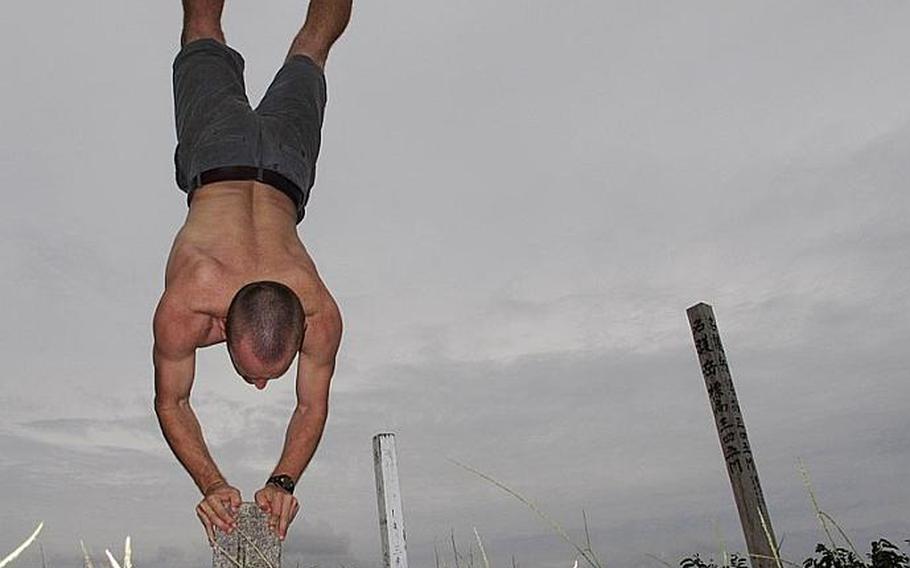 A small cement stone marks the summit of Nago Mountain. To celebrate reaching the top, I took a photo of myself attempting a handstand. This took a few attempts.