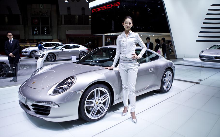 A woman models Porsche’s new 911 Carrera S.