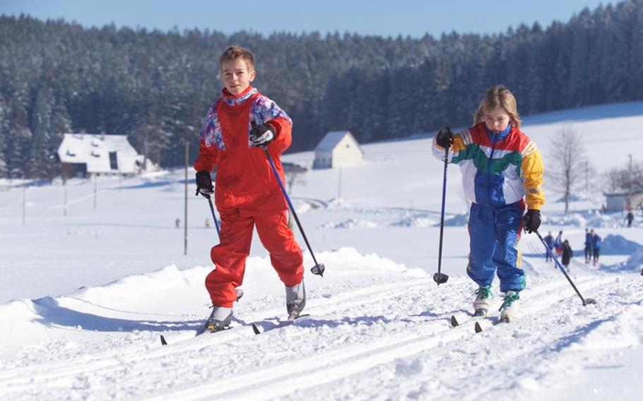 Children glide along cross country skiing trails near Schönwald im Schwarzwald, Germany.