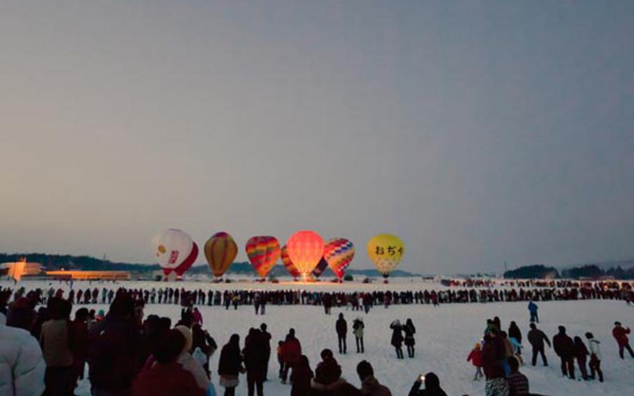 Crowds gather to see the fireworks and hot air balloons during the 2011 hot air balloon festival in Ojiya, Japan.