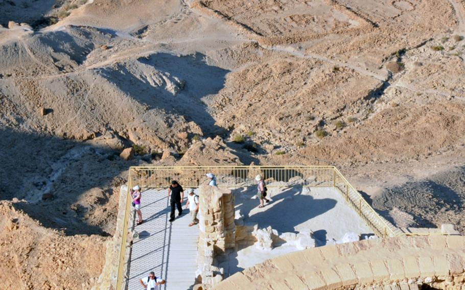 Tourists enjoy the view from what was once Herod's North Palace in Masada. From there, visitors can still see the remains of camps (background) established by Roman troops.