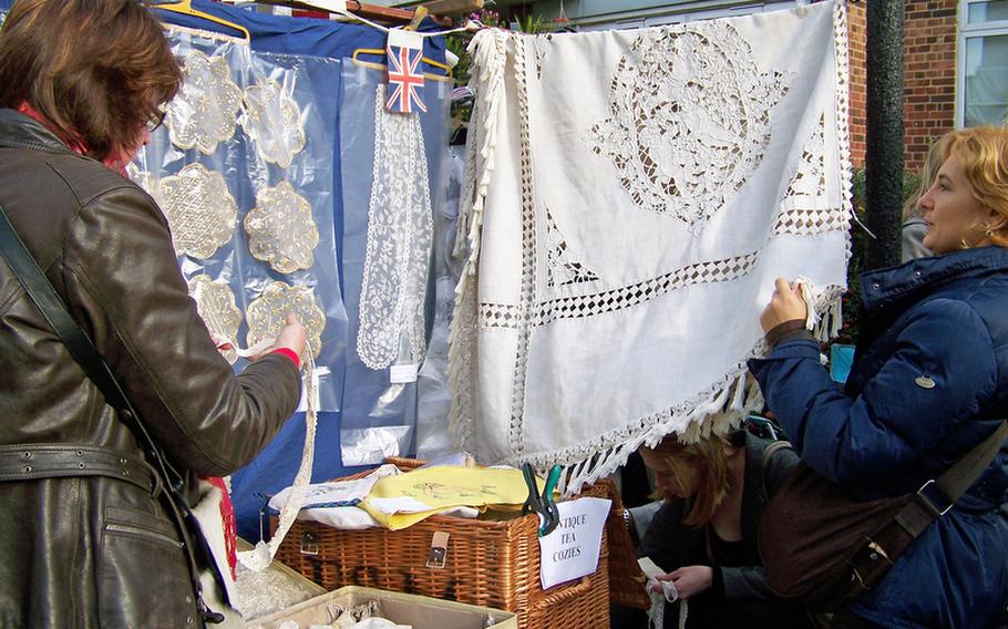A couple of shoppers inspect lacey linens and accessories at the Portobello Road Market. The blocks-long outdoor market offers an array of clothing, antiques, jewelry and other items and attracts hordes of tourists.
