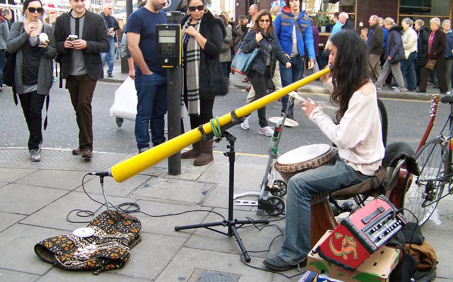 A one-man didgeridoo band plays for shoppers at the Portobello Road Market in Notting Hill.