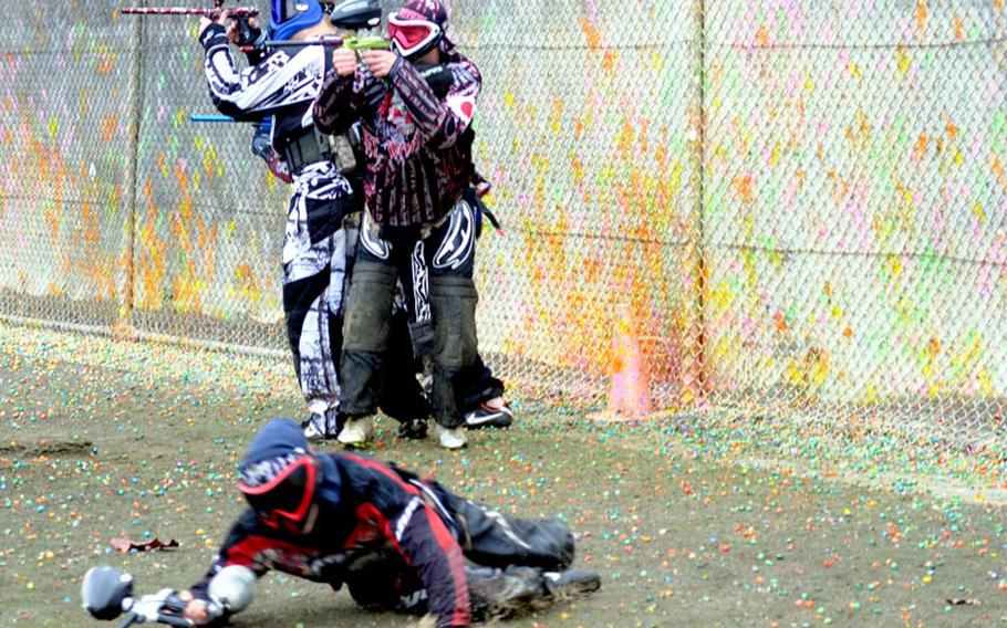 Moments after the referee signals the beginning of a game of speedball paintball, a player races to some protective cover by sliding and staying close to the ground. His teammates provide cover by firing paintballs at the opposition. The Feb. 25, 2012, match at Kadena Air Base, Okinawa, was part of a training session for the Ryukyu Kings team.