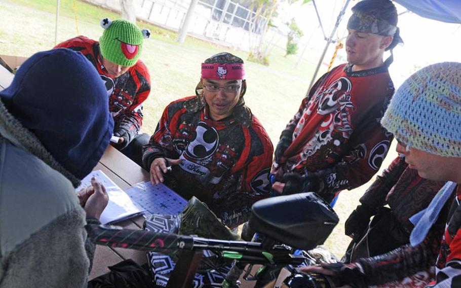 Marine Corps Gunnery Sgt. Conrad Bidal (seated, center) goes over team strategies between practice rounds of speedball paintball Feb. 25, 2012, at Kadena Air Base, Okinawa. Bidal is captain of the Ryukyu Kings, who were training for the Paintball Asia League Series tournament.