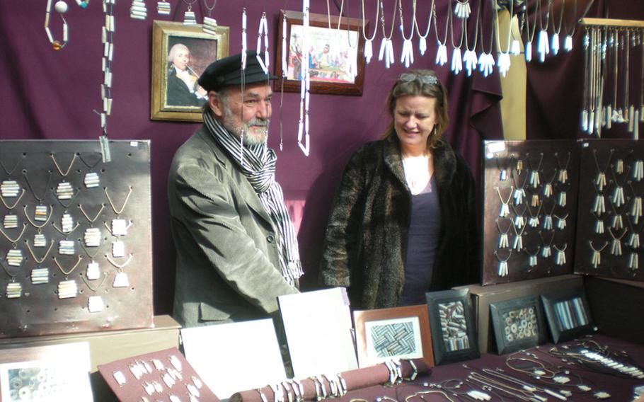 Clay smoking pipes gleaned from the banks of the Thames River are the key components of these market traders' jewelry at London's Old Spitalfields Market.