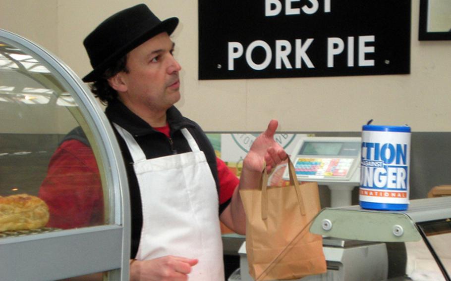 A vendor sports a porkpie hat to sell his handmade pork pies at London's Borough Market, known for its numerous offerings of food items.