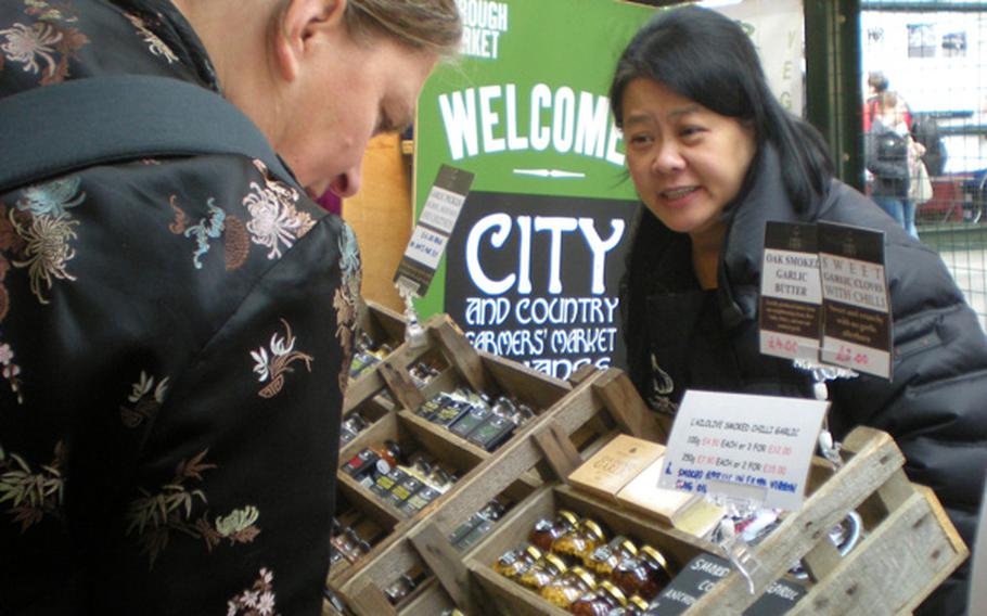 A seller from an Isle of Wight garlic farm shares insight with a customer about her specialty products.