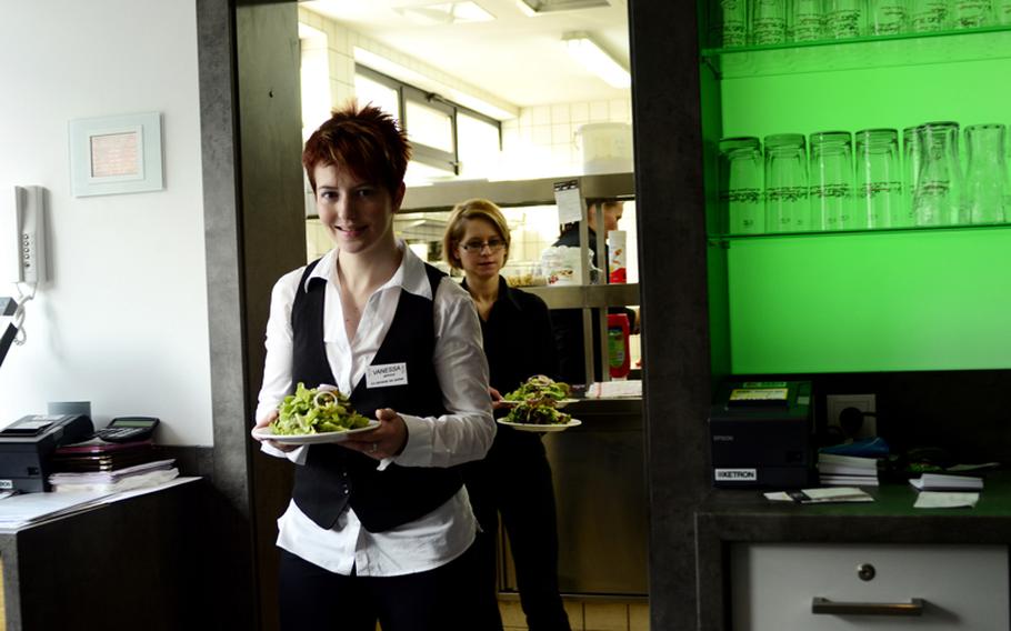 Vanessa Lorenz, an employee and part of the inspiration for Visione, serves a salad to customers.