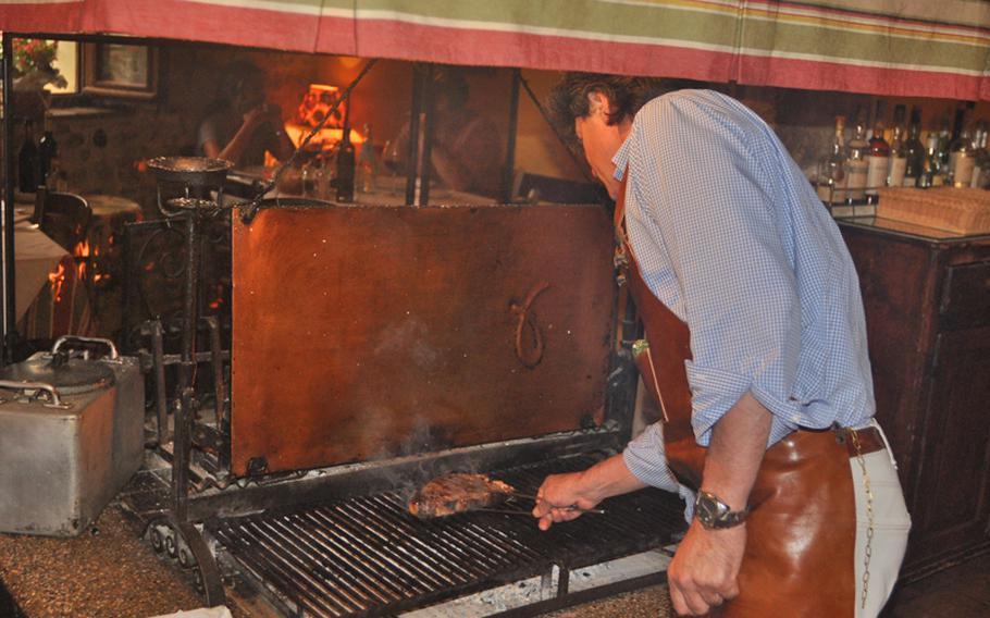 Mario Piol cooks a steak on the fireplace grill in the dining room of Antica Osteria Al Forno in Refrontolo, Italy. Members of the Piol family  have been cooking in the hilly countryside between Conegliano and Vittorio Veneto for generations.