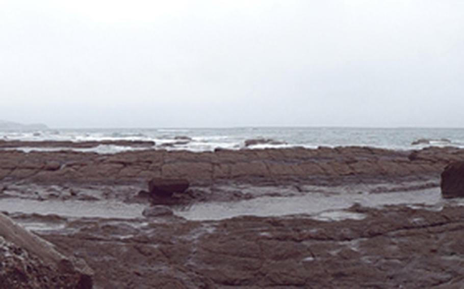 Outside the seawall lie the rocks of Ioujima. A bridge was built a year ago to connect the mostly deserted island to the larger island of Kyushu