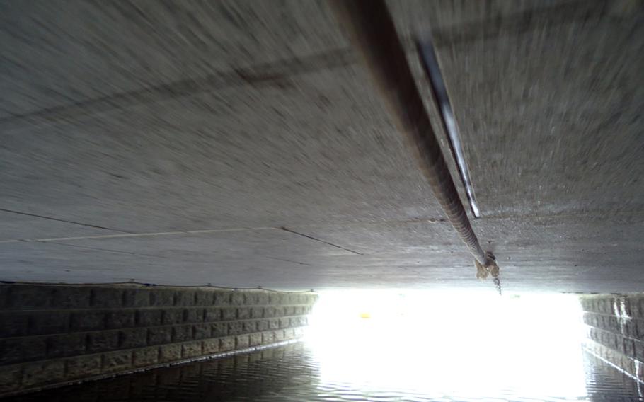 Guides use ropes to propel boats under the bridges of Yanagawa, because their bamboo poles are too long.