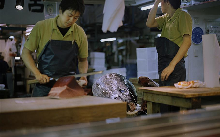 Workers cut a recently purchased tuna following the auction.