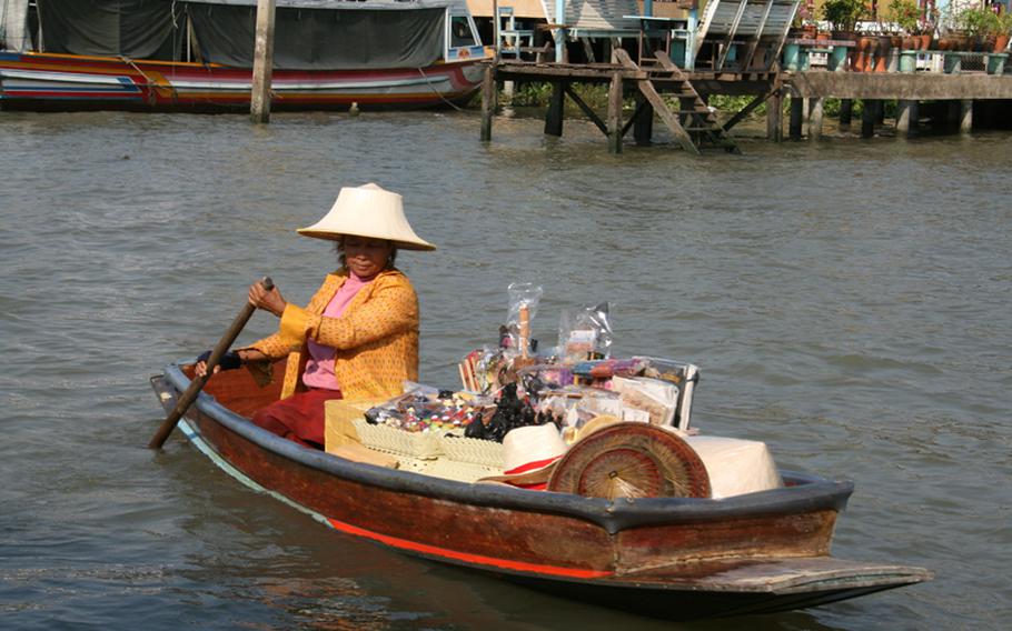 Canoe paddling vendors trawl the canals of Bangkok, selling trinkets and drinks to people on cruise ships or private longtail boats.