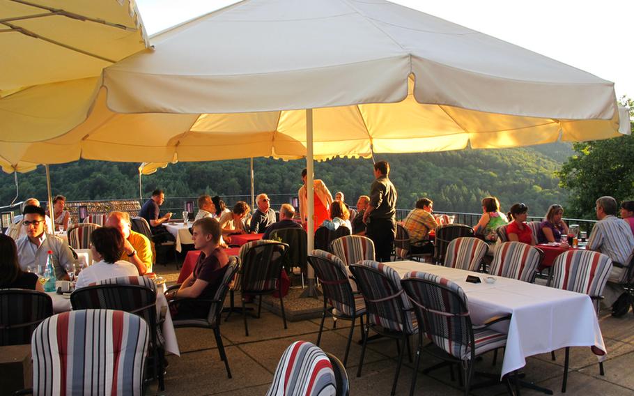 Diners enjoy the great weather and the spectacular views from the terrace of the Hirschhorn Castle restaurant, near Heidelberg, Germany.