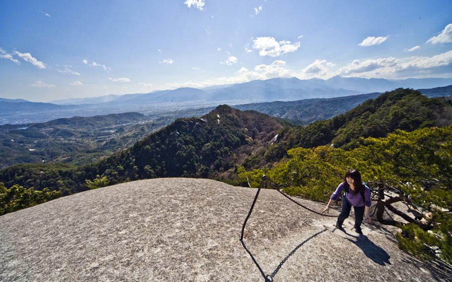 A hiker takes her final steps up to the top of Mount Yasaburo-take to enjoy the view of Mount Fuji and Japan's Southern Alps. This is one of the stunning views awaiting visitors to Shosenkyo Valley in Yamanashi prefecture. 