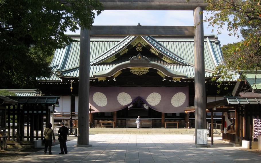 A woman prays at the Yasukuni Shrine main hall, or Haiden, after passing through the third Torii gate the morning of Oct. 16, 2012.