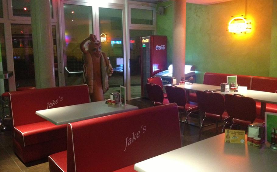 The diner portion of Jake&#39;s Diner-Bar in Stuttgart, Germany, features a hotdog statue draped in an American flag and pouring ketchup on his head. Jake&#39;s features all the fittings of a classic American diner.