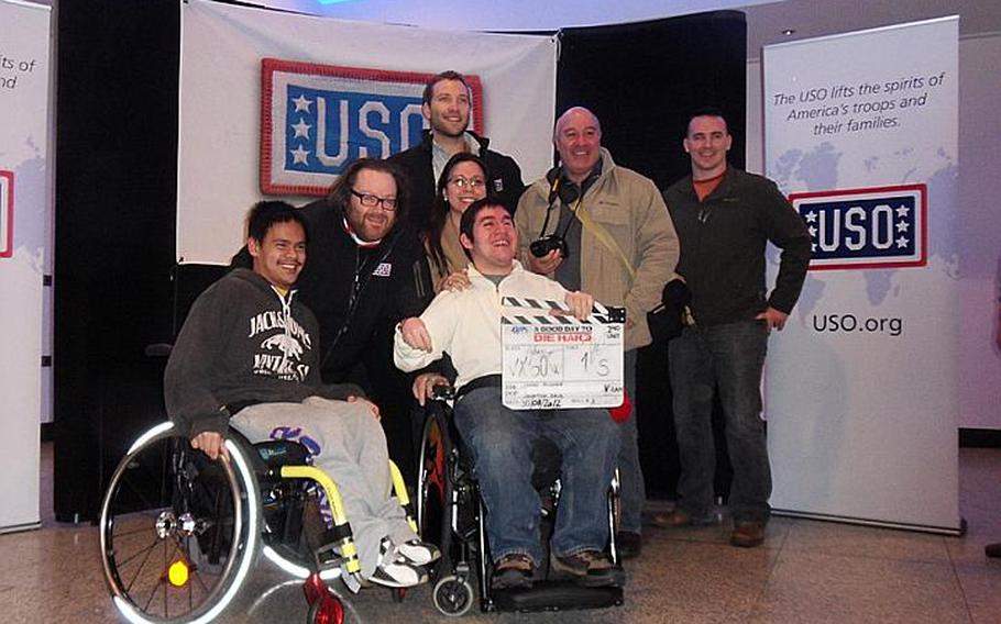 "A Good Day to Die Hard' director John Moore (second from left) and one of the movie's stars, Jai Courtney (back row, center), took time to pose with the wounded soldiers and their families who attended a Feb. 5 movie screening at Ramstein Air Base, Germany. 