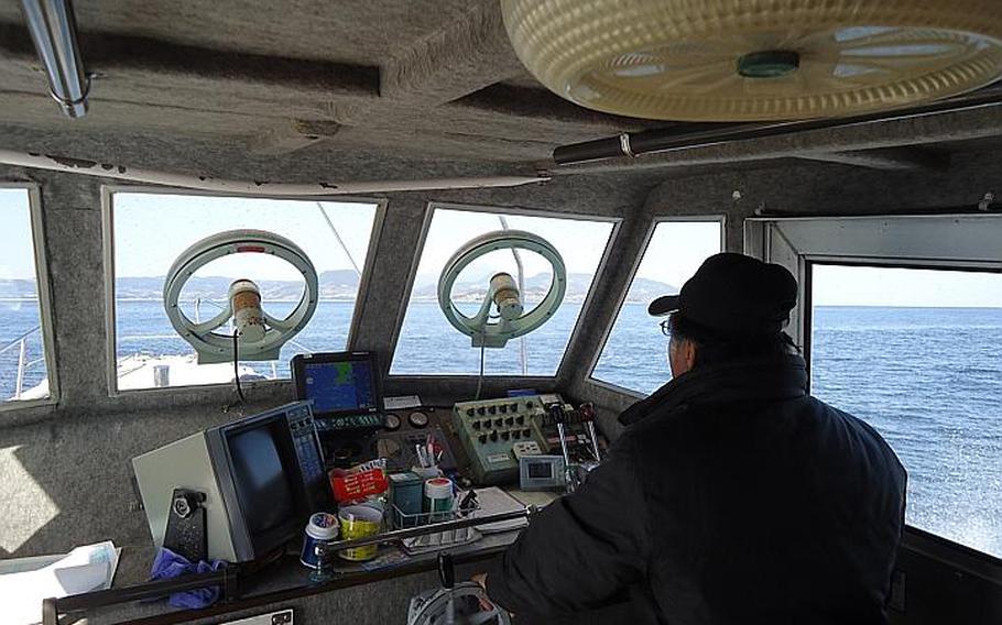 The Kazusa Iruka Watching boat captain surveys the landscape for dolphins in late February.