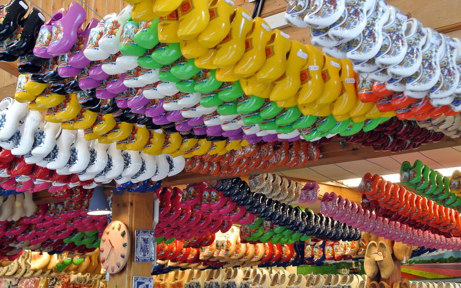 Souvenir wooden shoes in many colors hang from the ceiling of an Amsterdam shop.