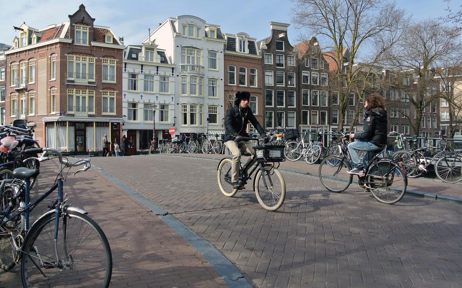 Bicyclists cross a bridge over the Prinsengracht canal in Amsterdam.