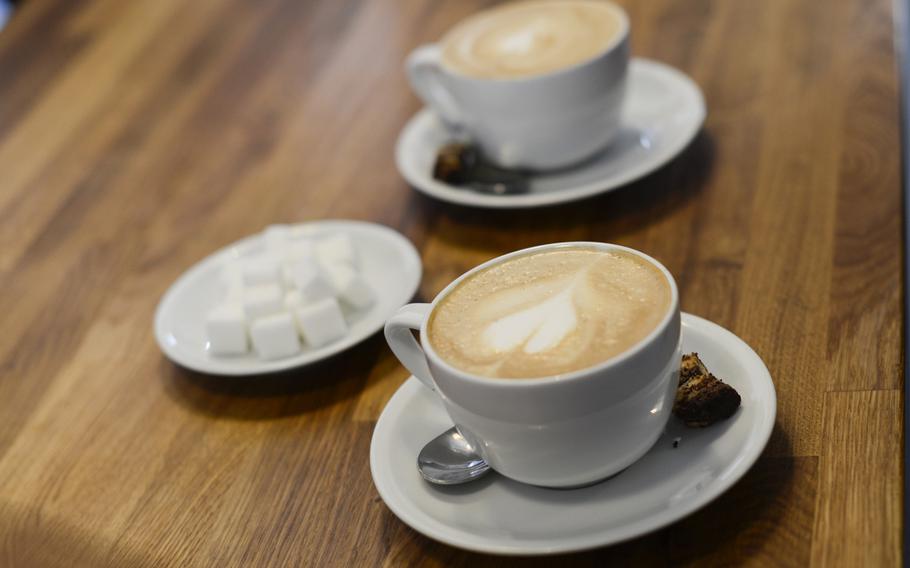 Two cappuccinos with hearts drawn on their foam sit on the counter at  Kaffeerösterei Kaiserslautern.