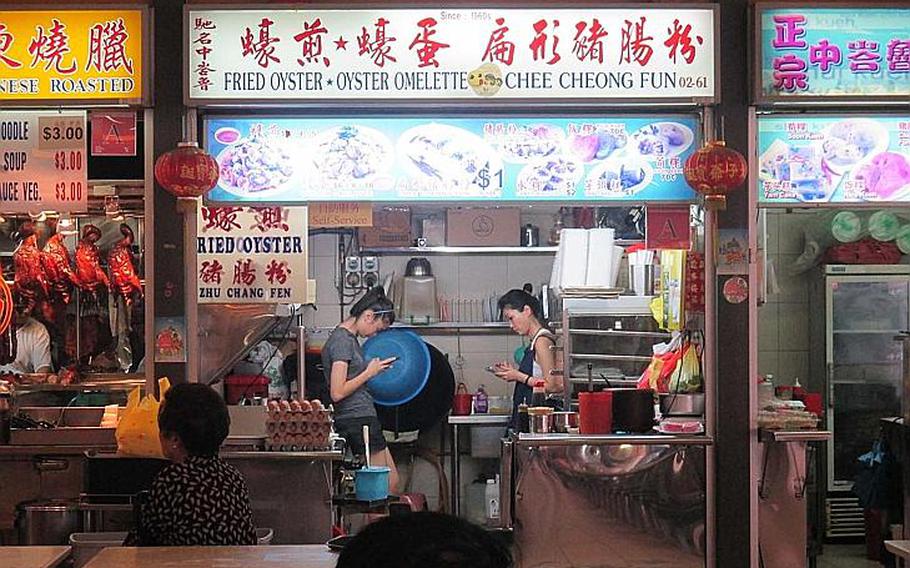 Cooks relax during a lull in business at Singapore's Tiong Bahru food center.