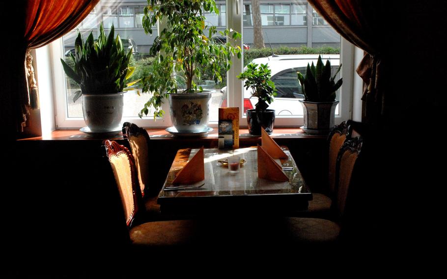 A darkened table surrounded by plants is shown at Restaurant. The eatery near Kaiserslautern offers what many buffet restaurants do not: a charming atmosphere. estaurant Asia, a popular restaurant and buffet in eastern Kaiserslautern, Germany. Each table is gracefully decorated, some enhanced with small aquariums at one end.